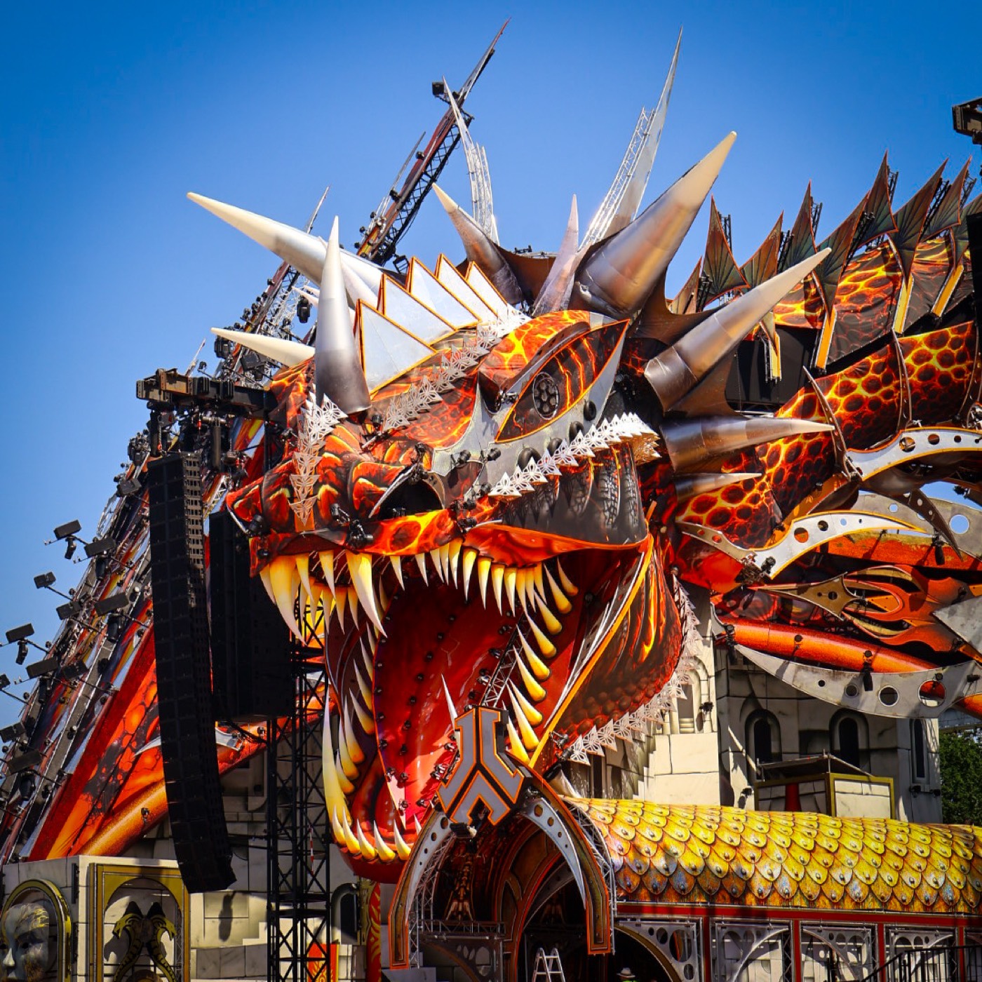 Gigantische drakenkop met vurige schubben domineert het hoofdpodium van een festival
