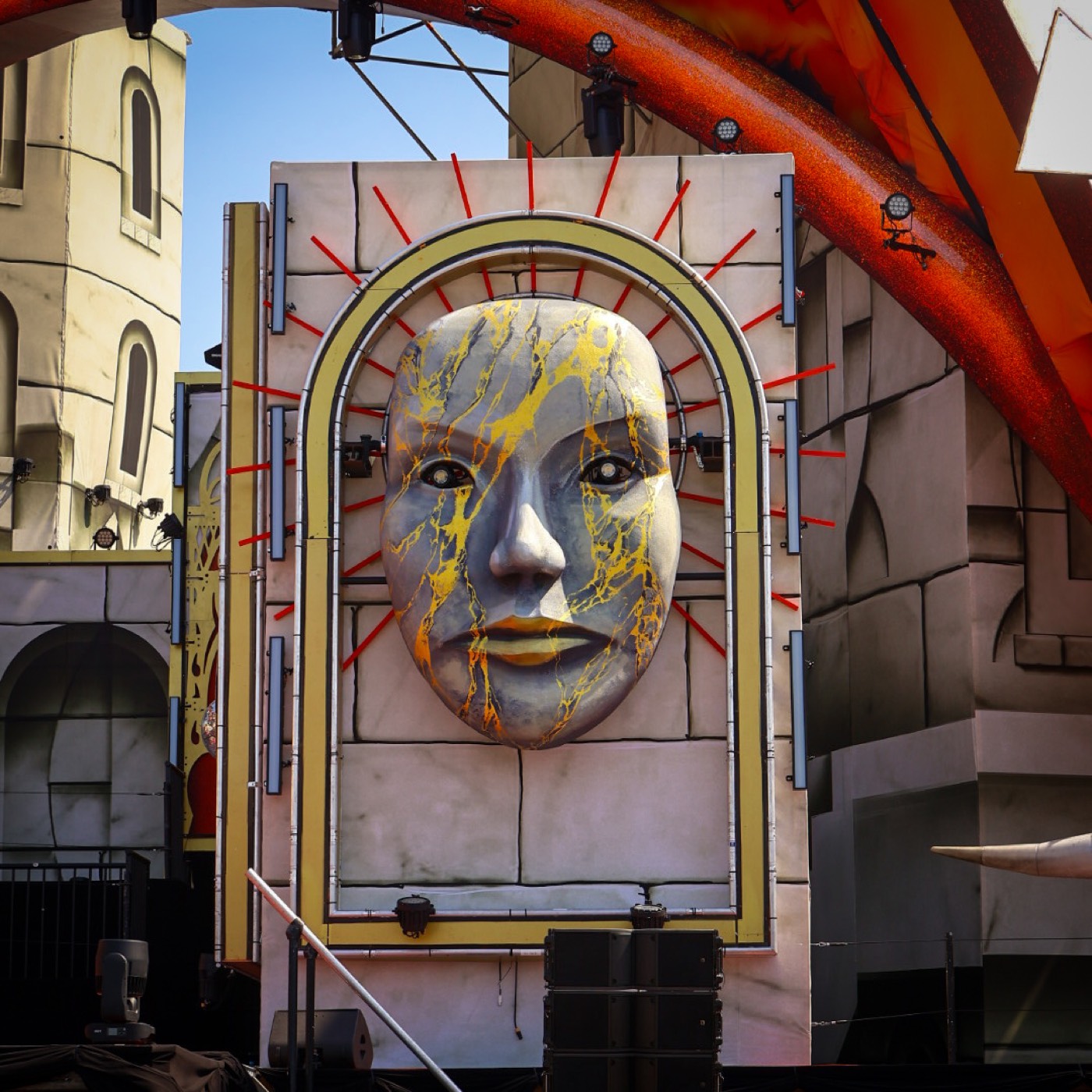 Sculpturaal marmeren gezichtsmasker met gouden aders op een festivalpodium