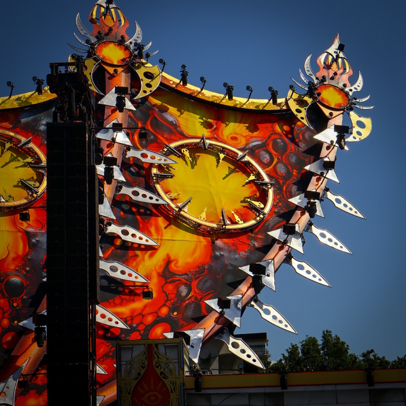 Podiumdecor met vlammenprint en zilveren zwaardornamenten in warm zonlicht