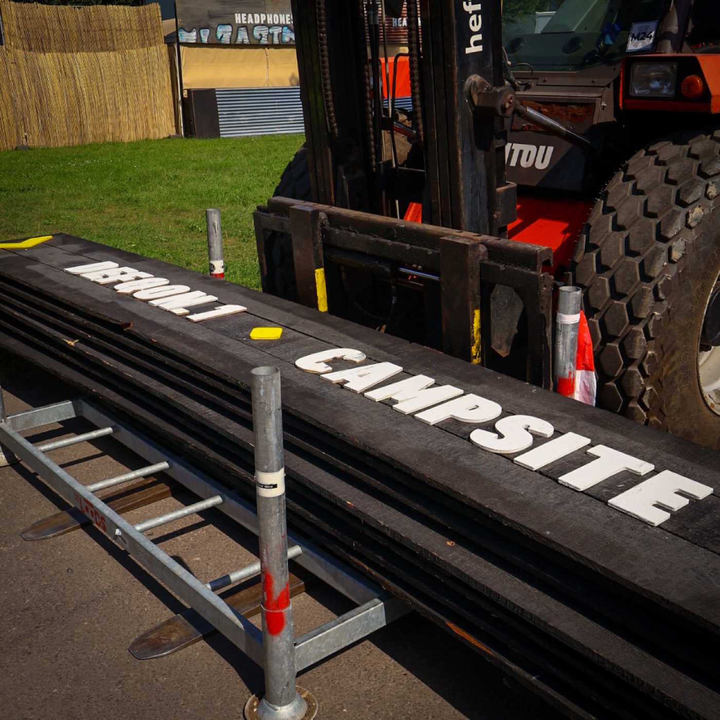 Handgemaakte witte letters voor festivalsigning op zwarte houten planken