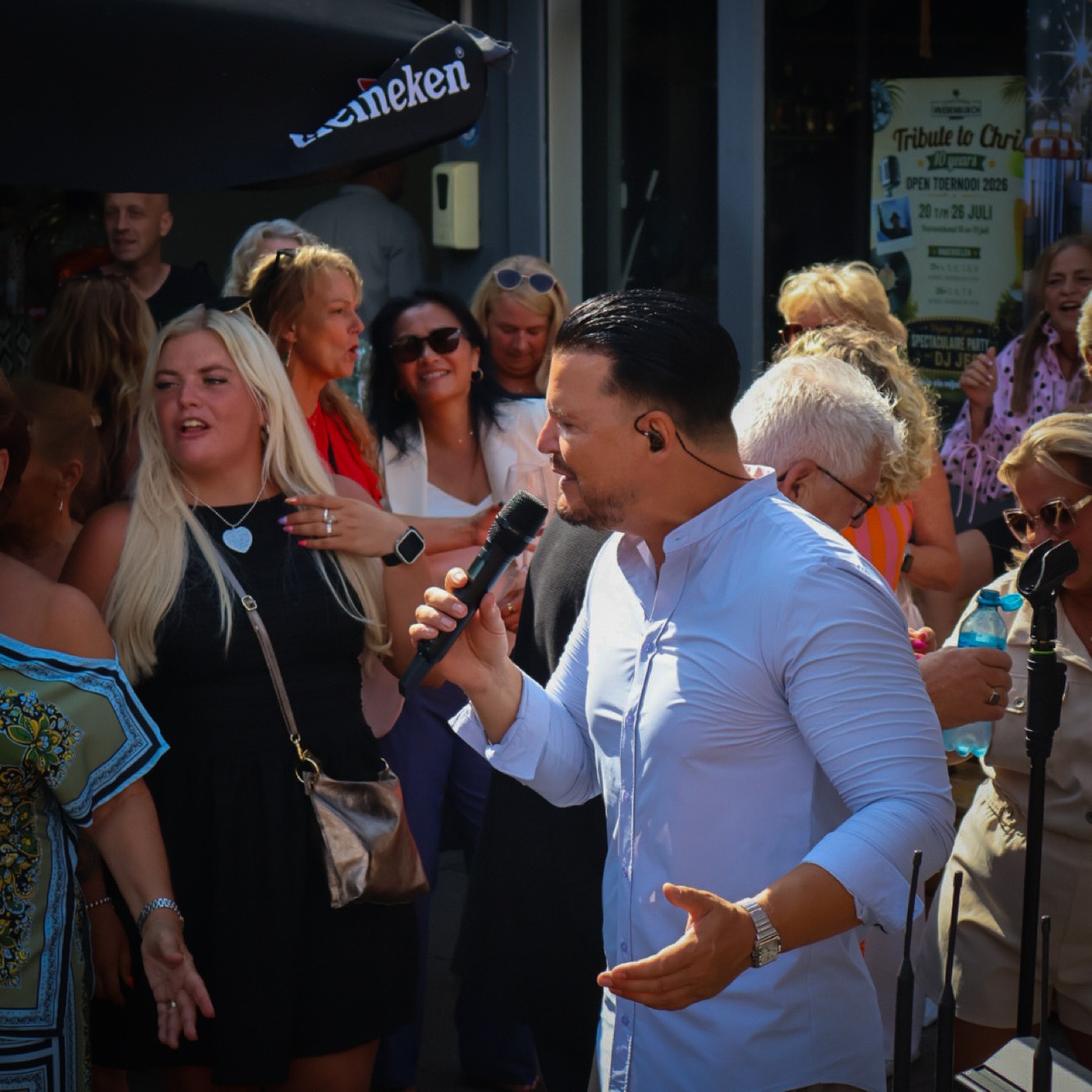 Zijaanzicht van Mike Peterson die zingt in warm zonlicht te midden van het publiek