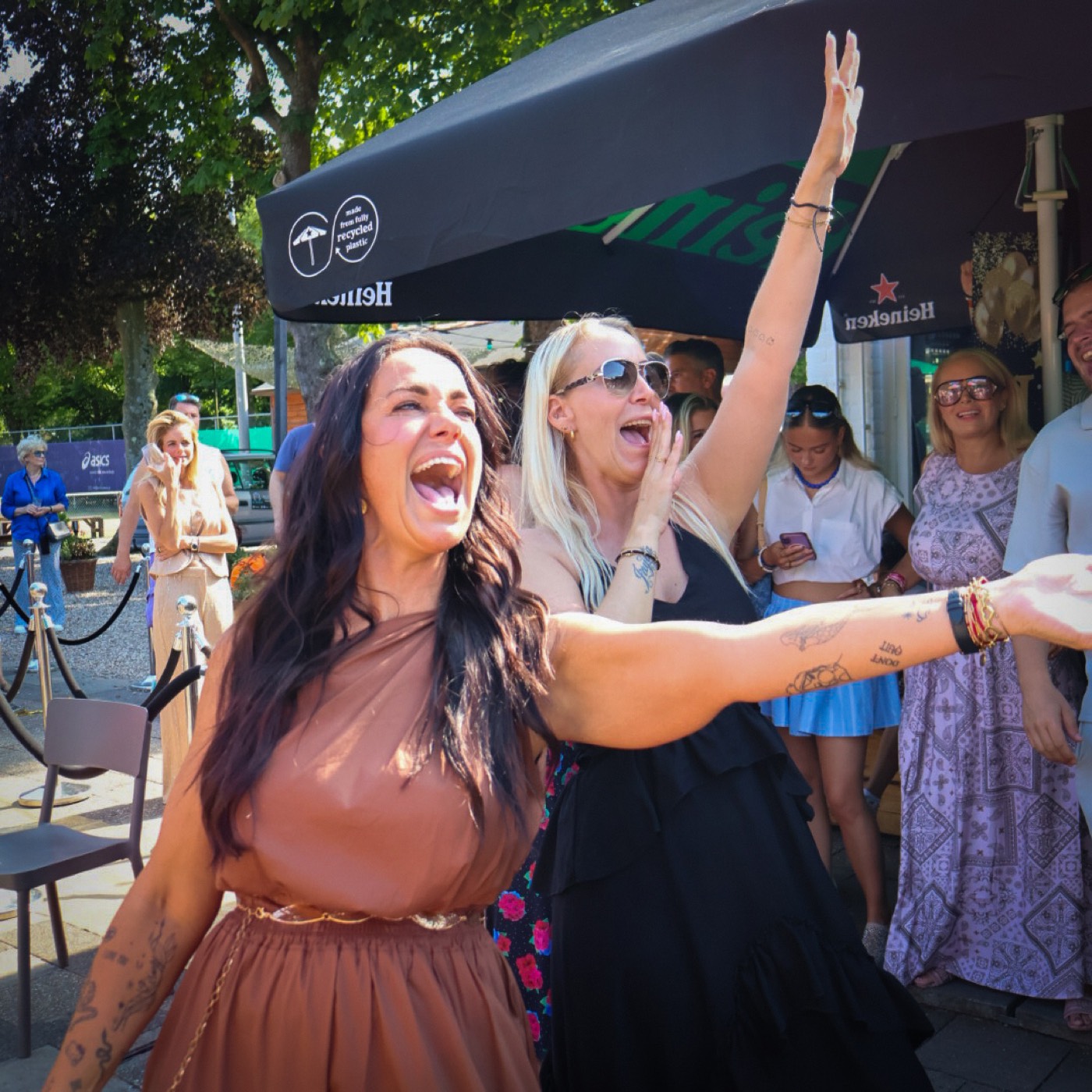 Twee vrouwen juichen en zingen mee in het publiek tijdens het optreden