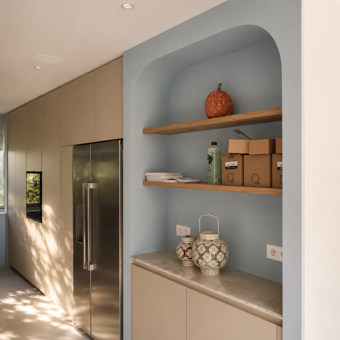 Beige maatwerkkeuken met lichtblauwe boognis en eiken planken in warm avondlicht